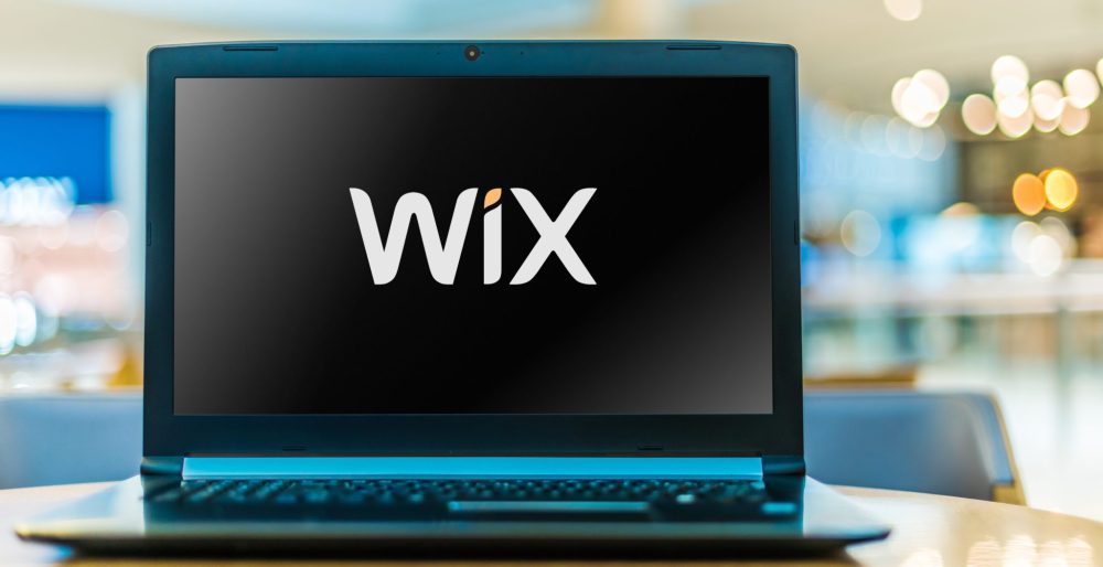Laptop computer displaying logo of Wix with a link to Contact