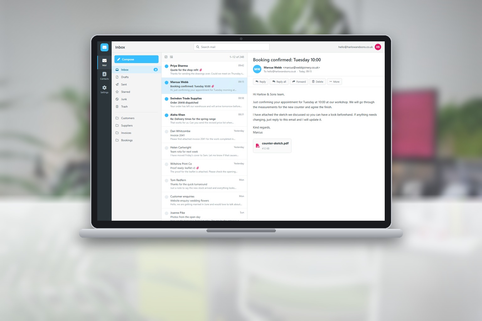 A laptop in a bright office showing a Roundcube webmail inbox with a message open