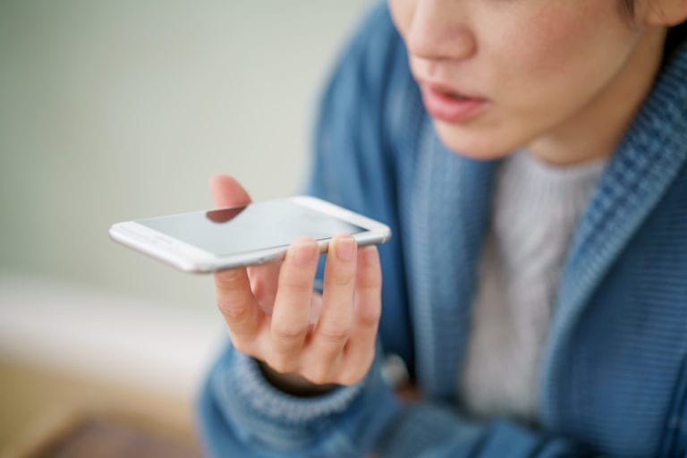 Woman speaking into a mobile device to search