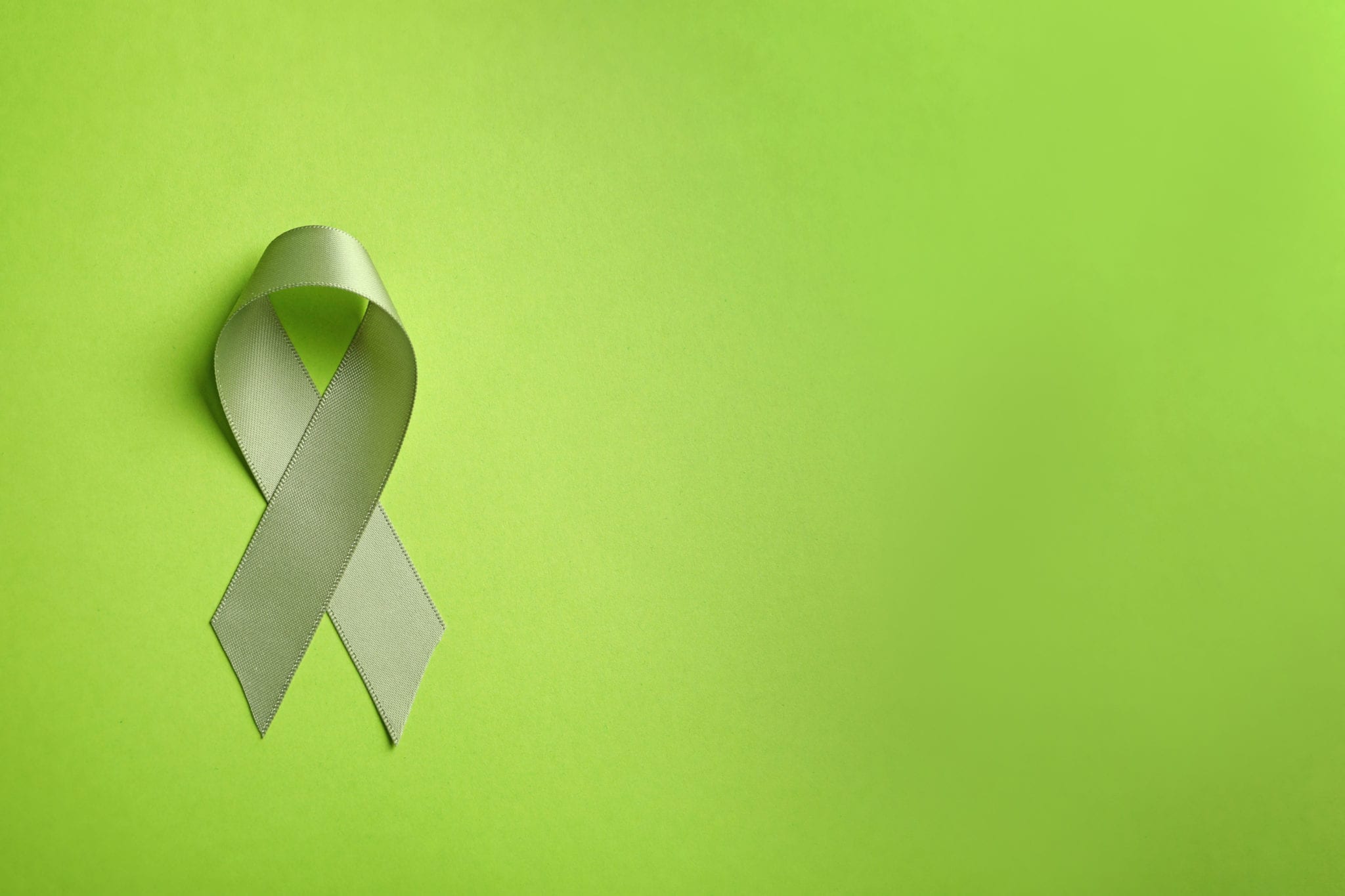 Green ribbon on colour background