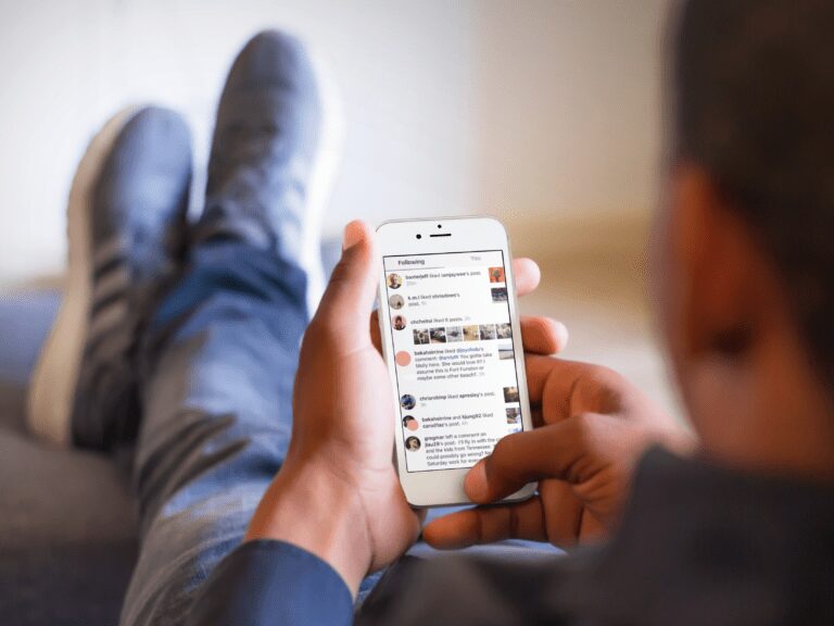 person sitting on a sofa checking Instagram account on a mobile