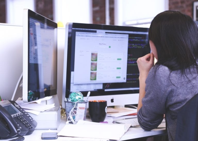 A woman working with a desktop on a office