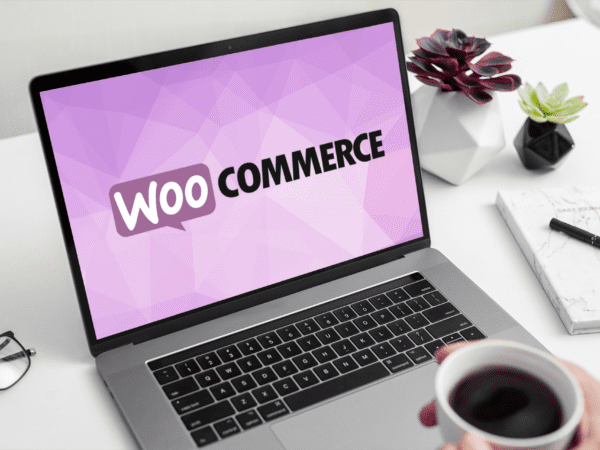 A person drinking coffee and watching WooCommerce website on a laptop
