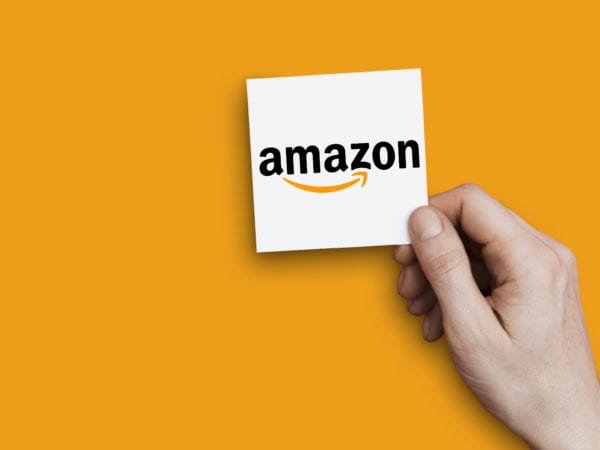 Hand holding Amazon logo