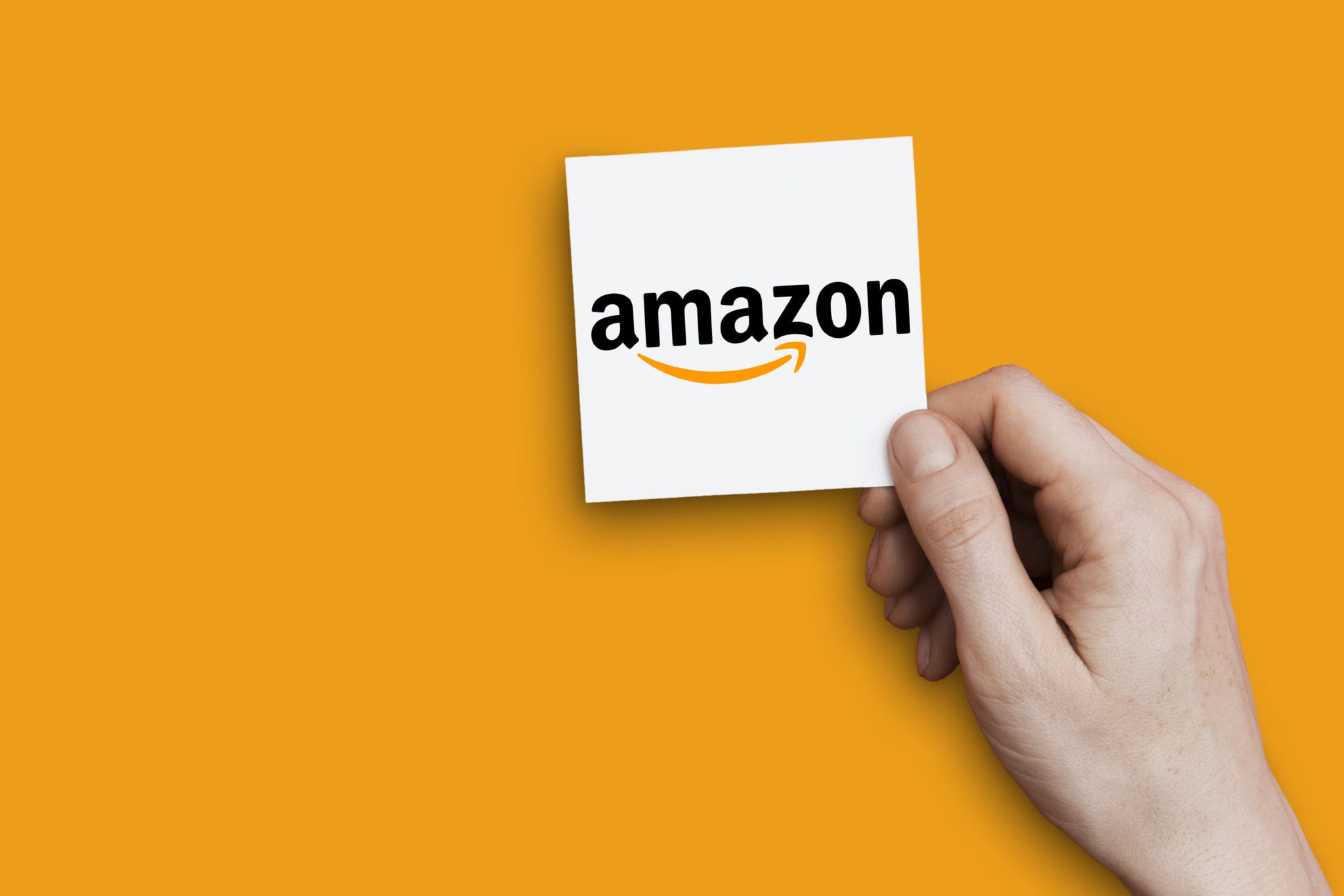 Hand holding Amazon logo