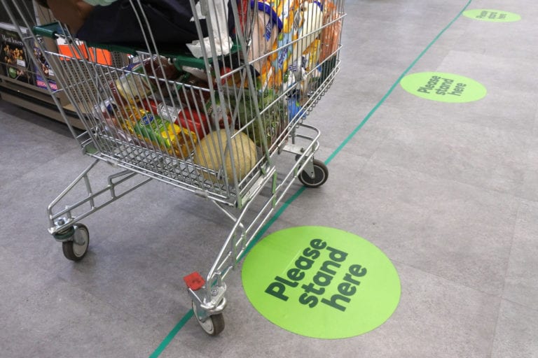Social distancing floor stickers in a supermarket queue