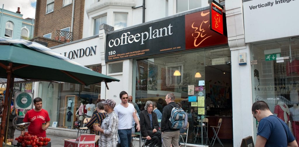 coffee plant shop on the street with people walking infront of the shop