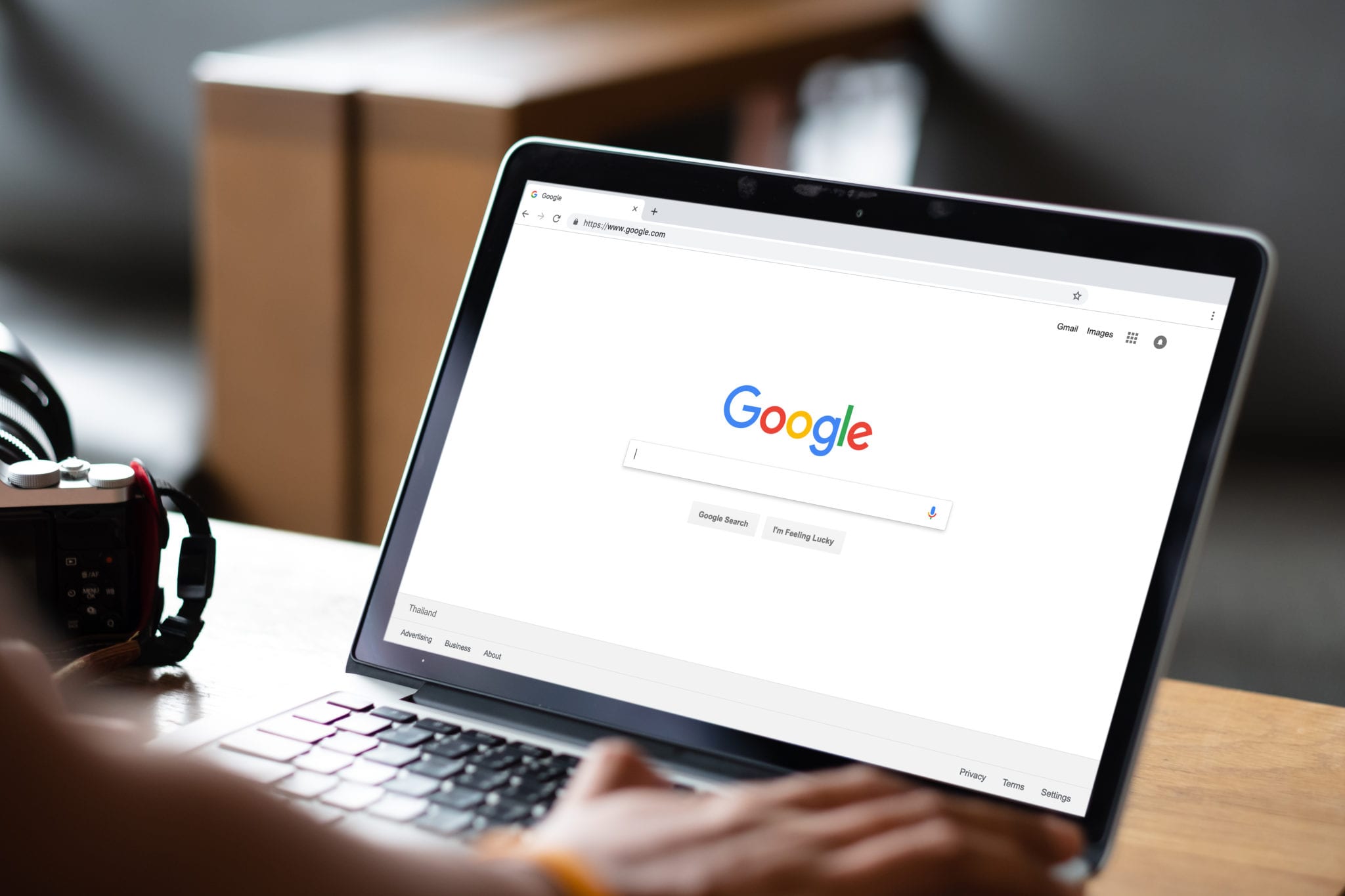 User browsing Google homepage on a laptop
