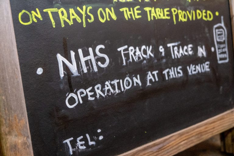 A handwritten sign at a pub about NHS track and trace