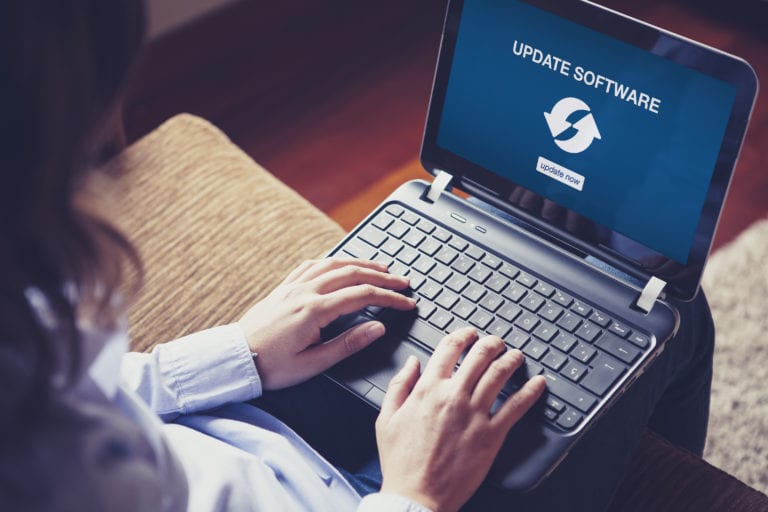 Woman updating laptop software at home