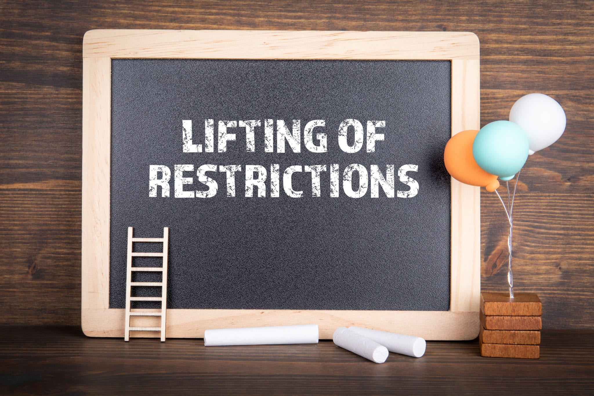 Lifting of restrictions. Chalk board on a wooden background