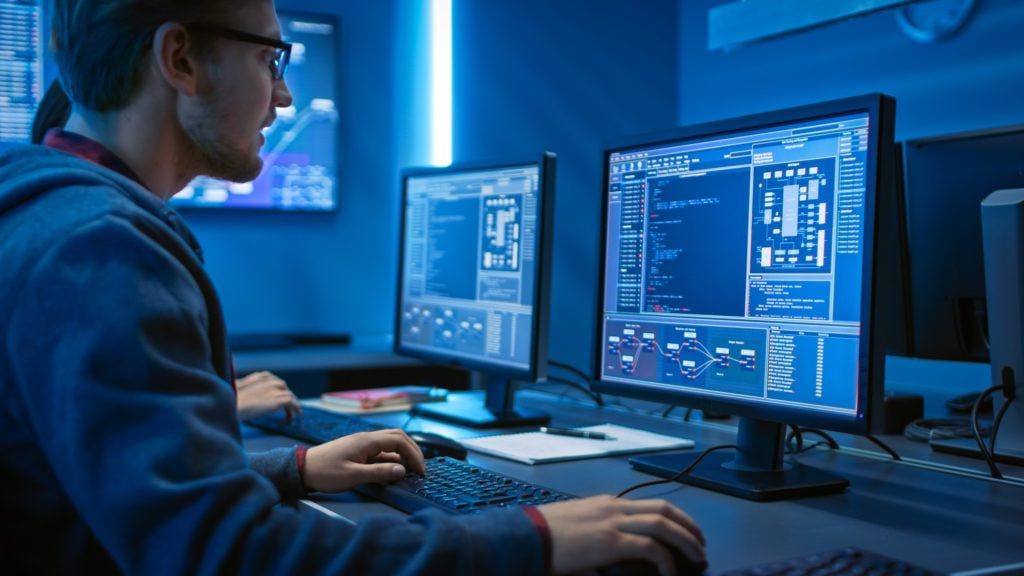 Smart Male IT Programer Working on Desktop Computer.