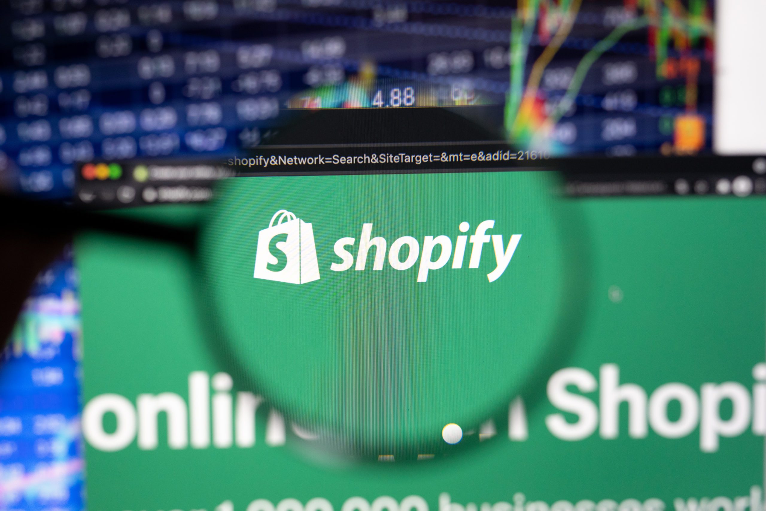 Shopify company logo on a website with blurry stock market devel