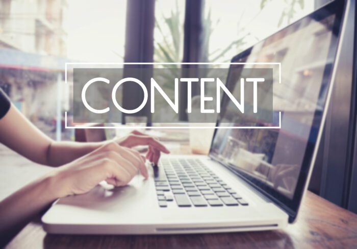 Person typing on a laptop with the word 'Content' displayed prominently, representing web content creation