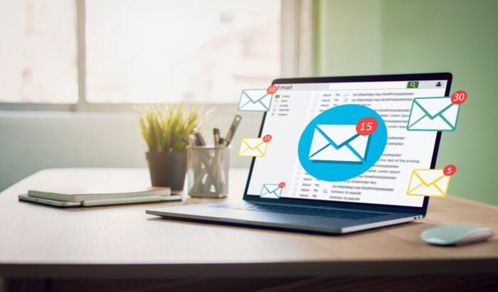 Laptop with colourful email notification graphics illustrating the comparison between branded and personal sender names