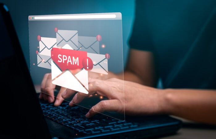 A visual of a laptop screen displaying a "Spam" warning, symbolising the use of SpamAssassin for email filtering and blocking spam.