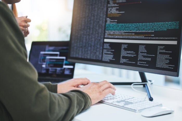 A person working on web design code in an office, showcasing the technology behind small business websites and the web development process.