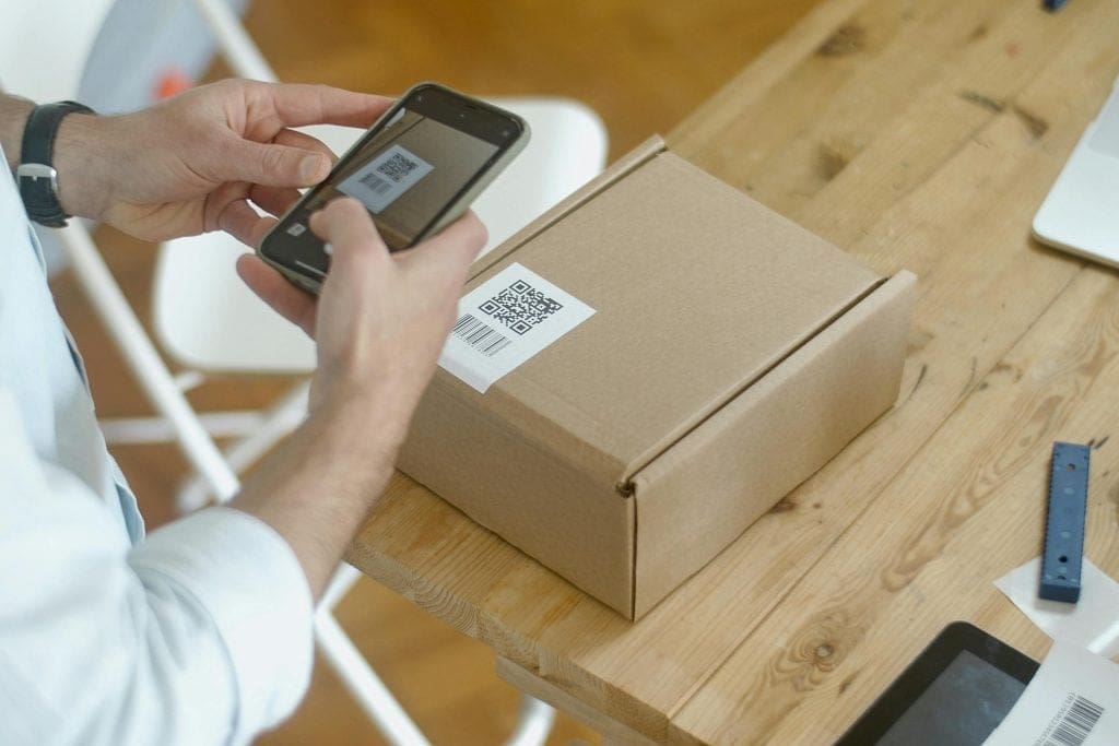 Person scanning a QR code that is stuck to a parcel box using a smartphone