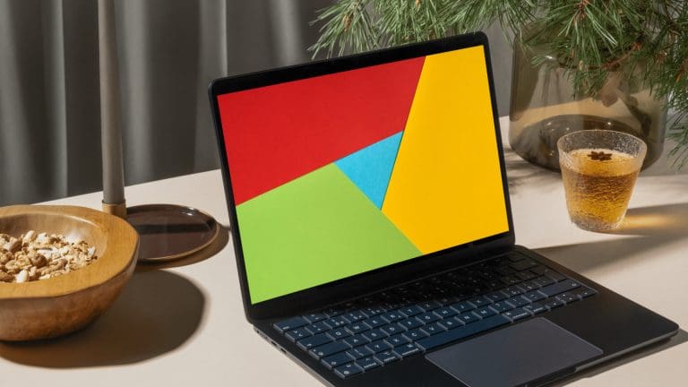 Laptop on a table with paper cutting design on the screen that mimics the colours in the Google logo