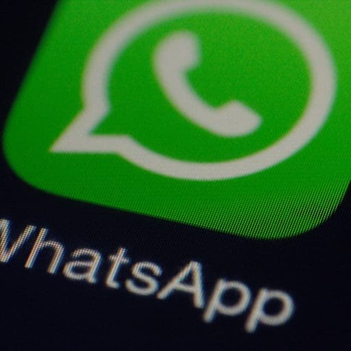 Smartphone screen displaying app icons with a focus on the green WhatsApp icon